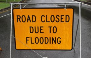 Supporting First Super members in QLD and NSW. Road sign with road closed due to flooding